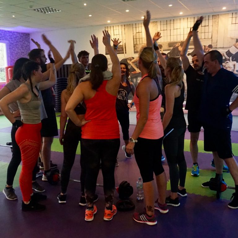 Kursteilnehmer:innen im Kreis beim Abklatschen