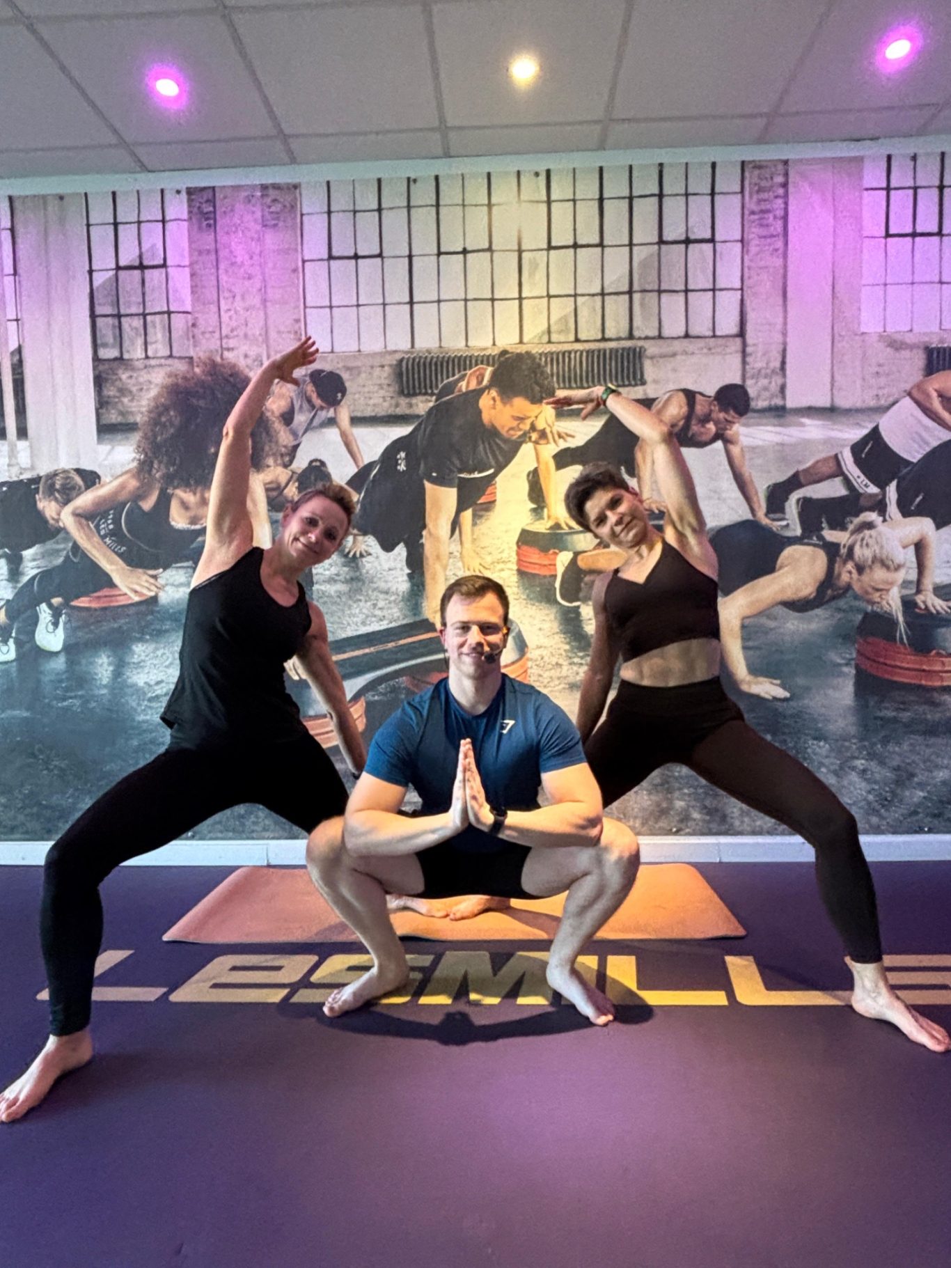 Drei Trainer, zwei weiblich, einer männlich in Yogaposen