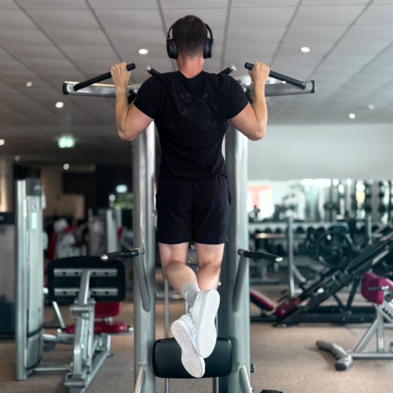 Mann beim Training an der Multipresse trainiert